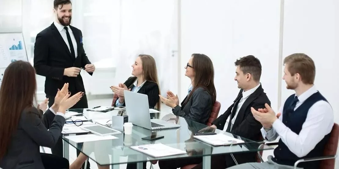 A presenter shares work with colleagues in a bright professional setting.