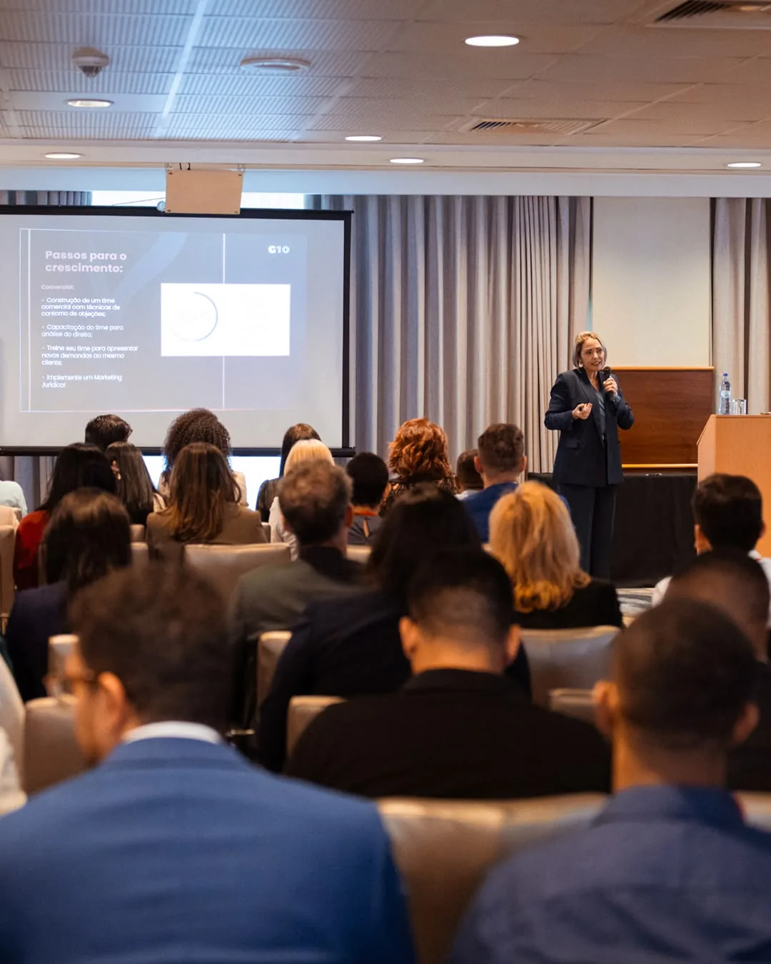 A speaker presents to an audience at a professional event.
