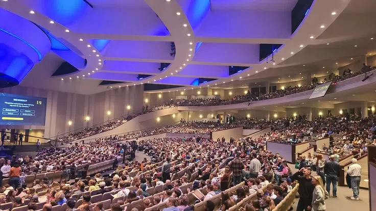 A large audience gathers in a university-style auditorium.
