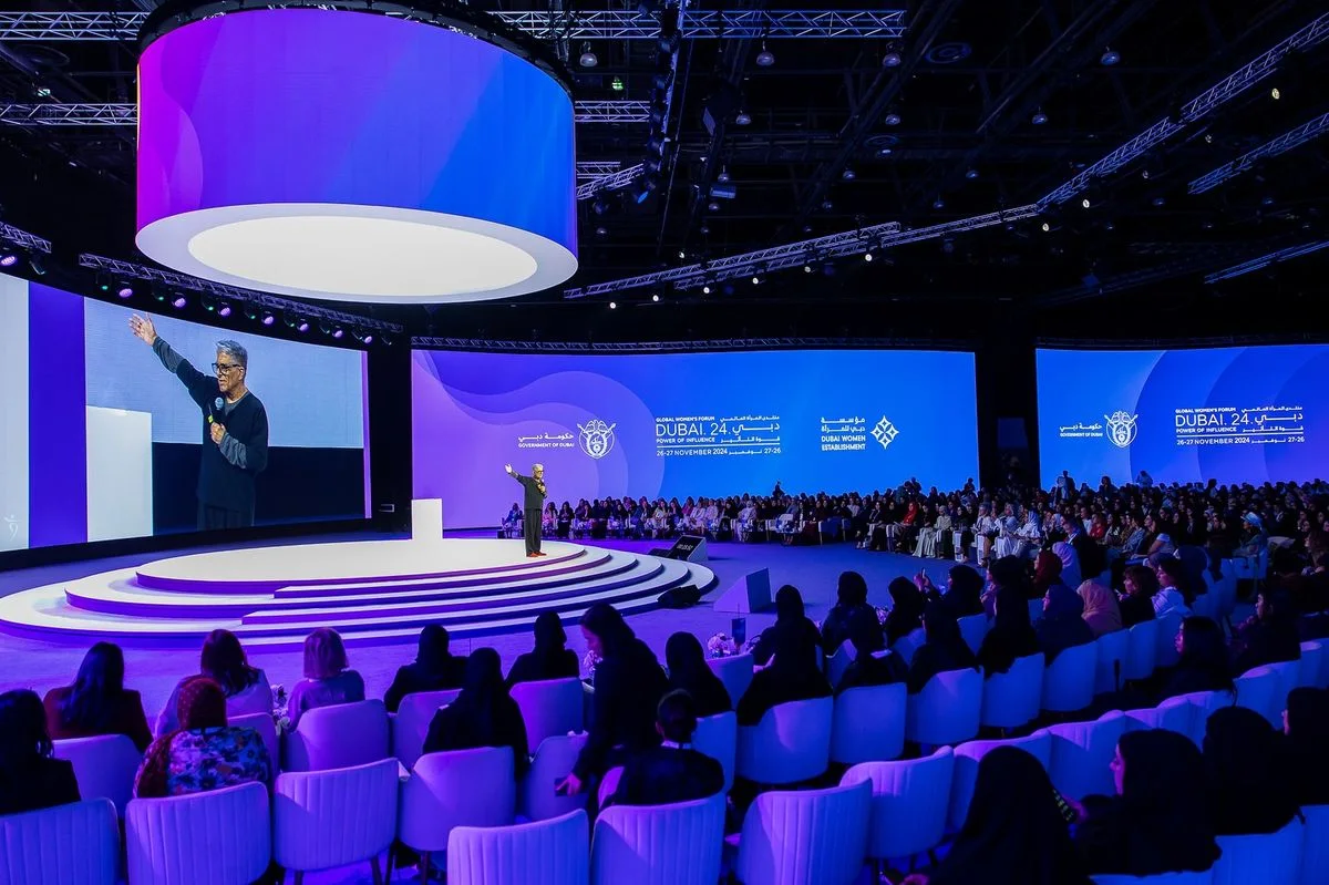 A speaker and audience participate in an international education symposium.